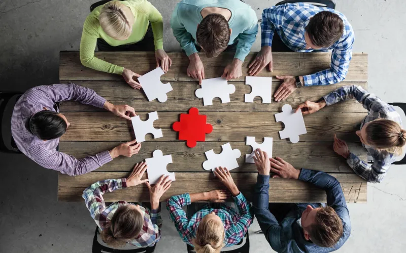 business people and puzzle on wooden table  teamwork concept 1