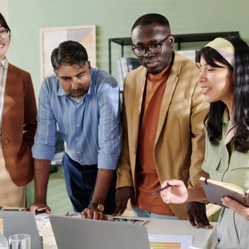group of young adults around laptops