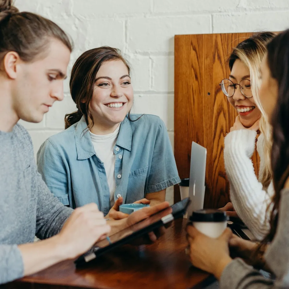 group of young adults around ipad