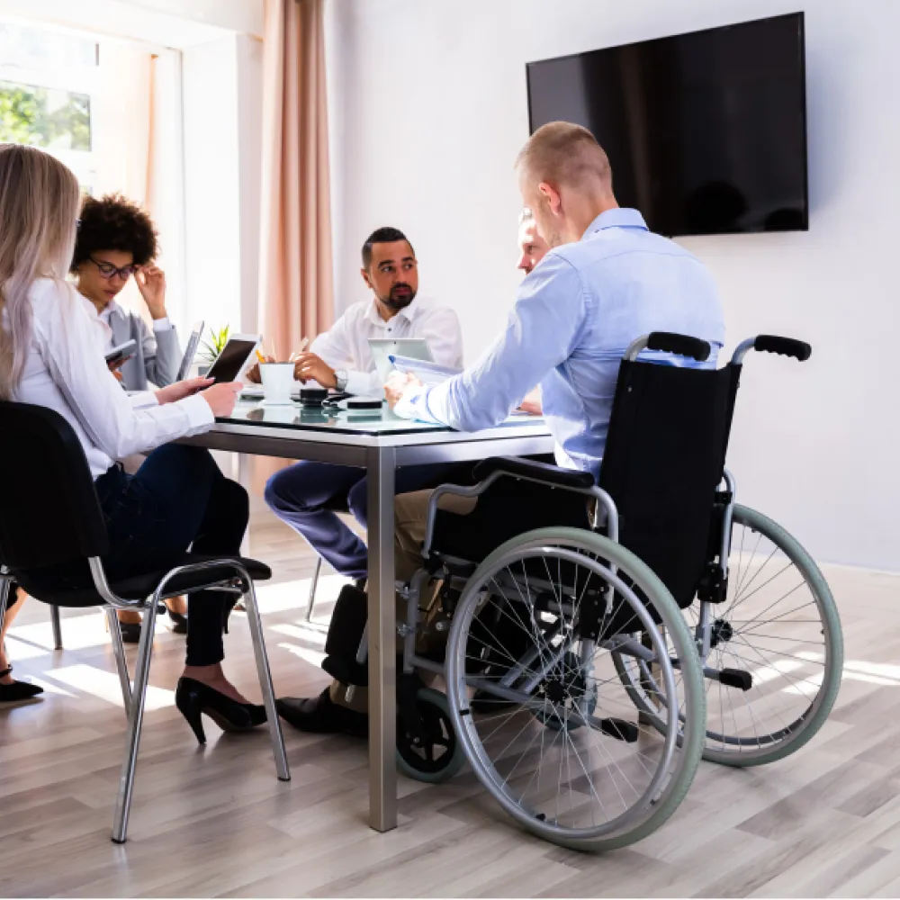 group around board table with wheelchair user