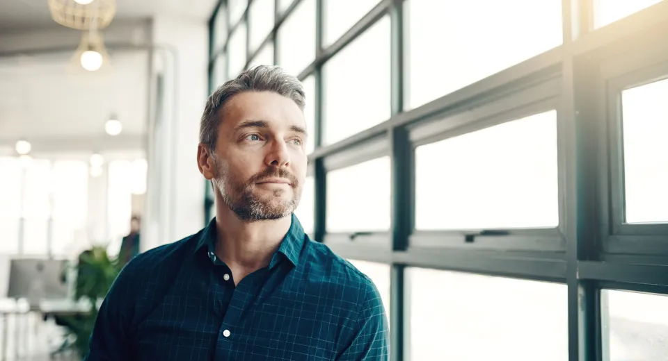 man looking off camera next to window