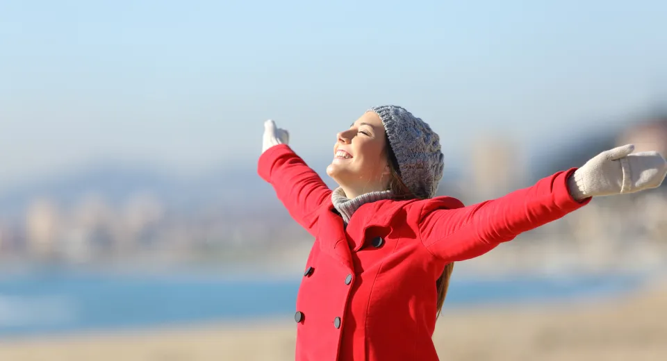 woman in red coat on beach